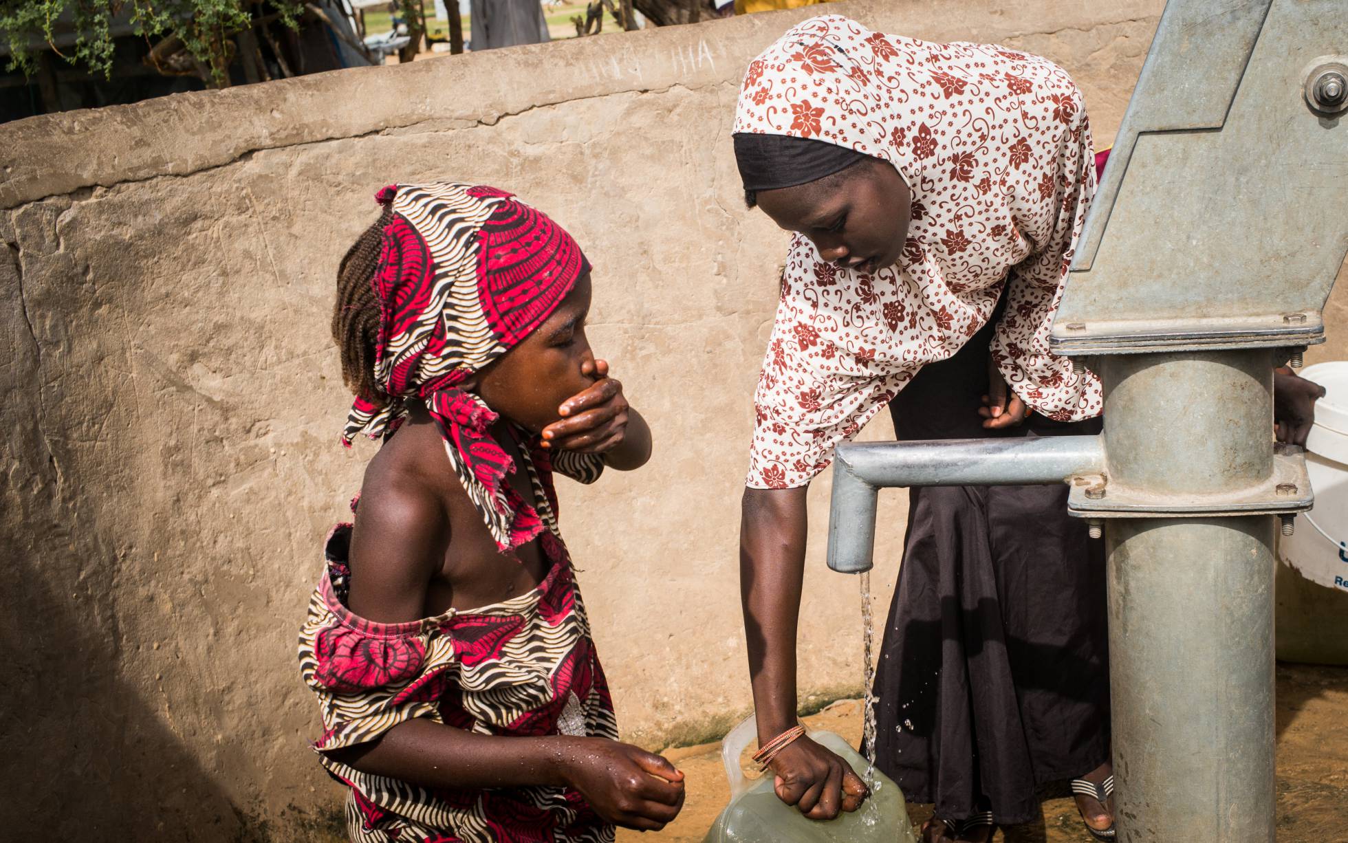 En tan sólo cinco años, “Khadi”, como la llaman sus amigos, ha vivido en cinco lugares diferentes a causa de los conflictos armados o la sequía. Actualmente reside en el campo de refugiados de Daresalam, en la región del Lago Chad. En la foto, Khadija recoge agua junto a su hermana pequeña. En tan sólo cinco años, “Khadi”, como la llaman sus amigos, ha vivido en cinco lugares diferentes a causa de los conflictos armados o la sequía. Actualmente reside en el campo de refugiados de Daresalam, en la región del Lago Chad. En la foto, Khadija recoge agua junto a su hermana pequeña.