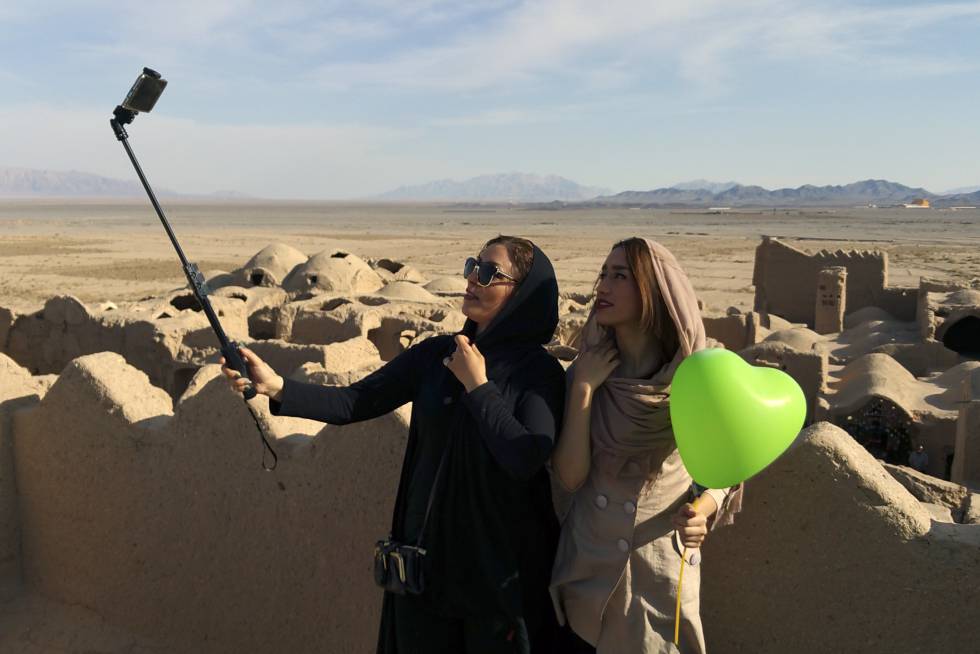 Dos jóvenes se fotografían en la ciudadela de Saryadz, Irán