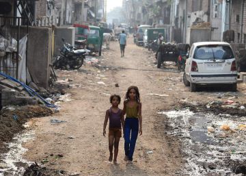 Niños indios caminan por una calle repleta de basura, en Nueva Delhi (India).  Niños indios caminan por una calle repleta de basura, en Nueva Delhi (India).