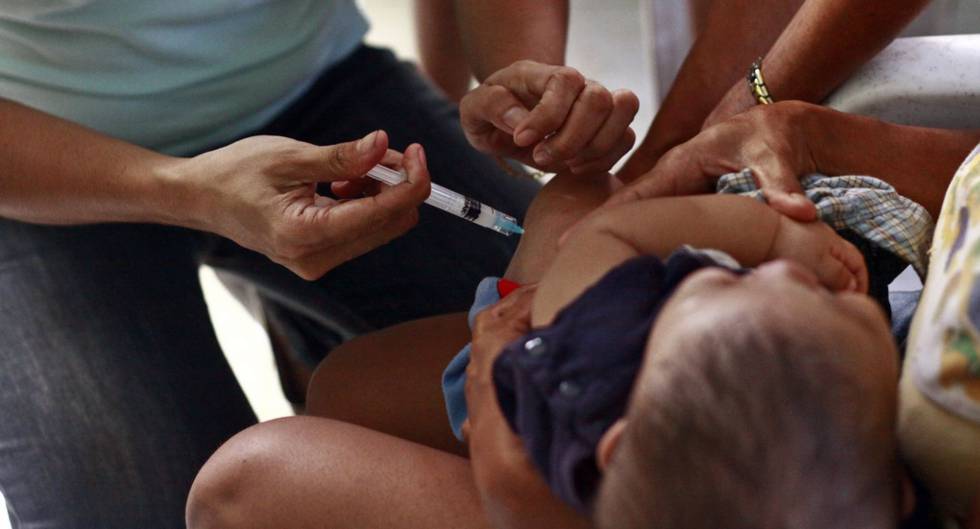 Un trabajador de la salud inyecta una vacuna a un niño.