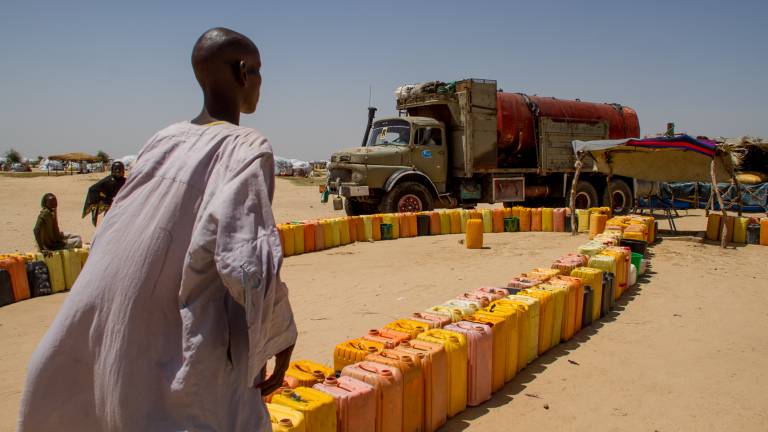 Un vecino de Kindjandji, en Níger, observa cómo uno de los camiones descarga agua para los refugiados. Un vecino de Kindjandji, en Níger, observa cómo uno de los camiones descarga agua para los refugiados.