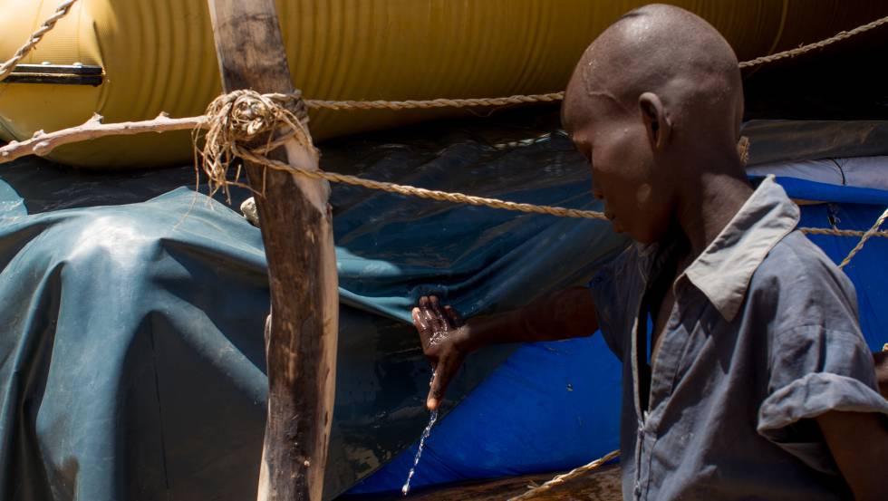 Un crío tapa una rendija por la que sale agua en una de las 'bladder' o vejigas de Kindjandji.