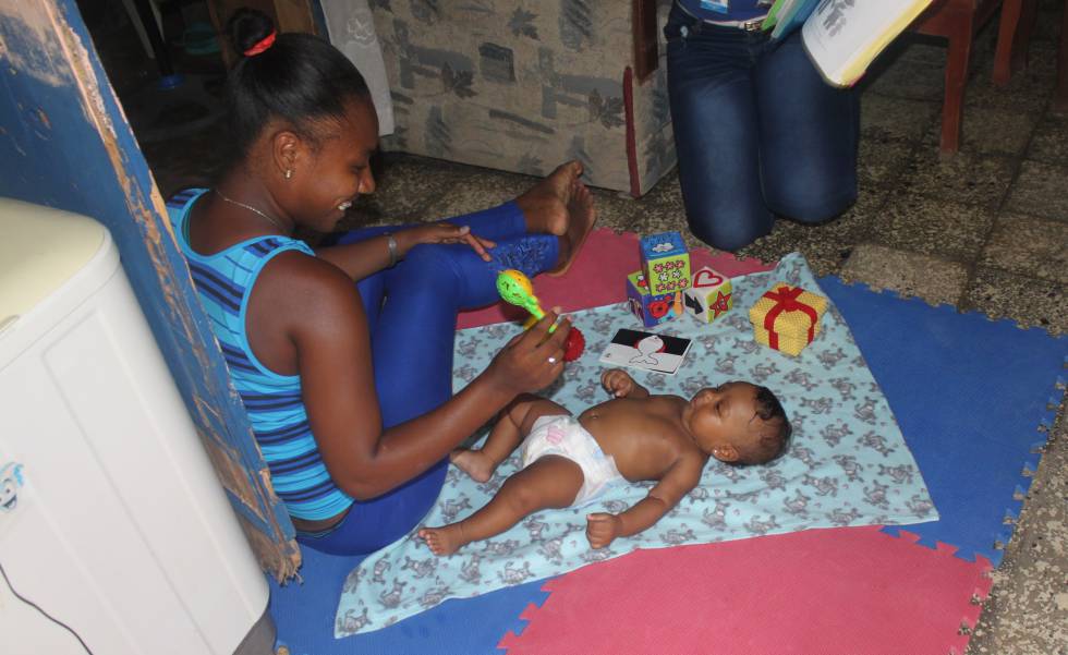 Marieta (17 años) estimula en su casa a su hija Francesca (4 meses), guiada por una animadora.