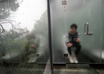 Un turista visita un ba&ntilde;o p&uacute;blico de cristal, en el lago Shiyan (China). 