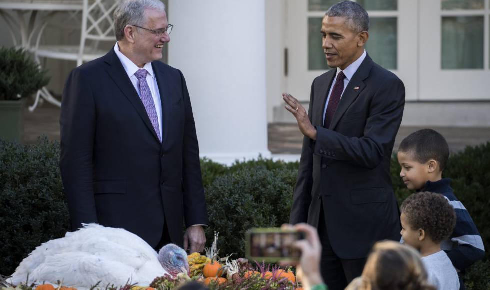 El presidente de Estados Unidos, Barack Obama (d), perdona a 'Tot', el pavo nacional del Día de Acción de Gracias, ante la mirada del presidente de la Federación Nacional de pavos, John Reicks y sus dos sobrinos.