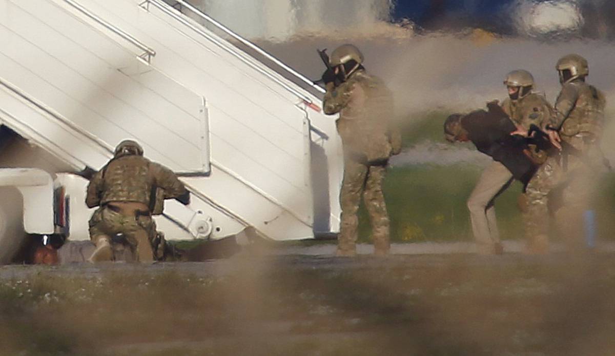Varios agentes detienen a uno de los secuestradores del avión libio.