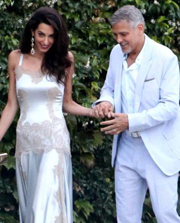 En la imagen, el actor le ayuda a entrar a una embarcación de su casa en el Lago di Como (Italia) para acudir a una cena familiar.