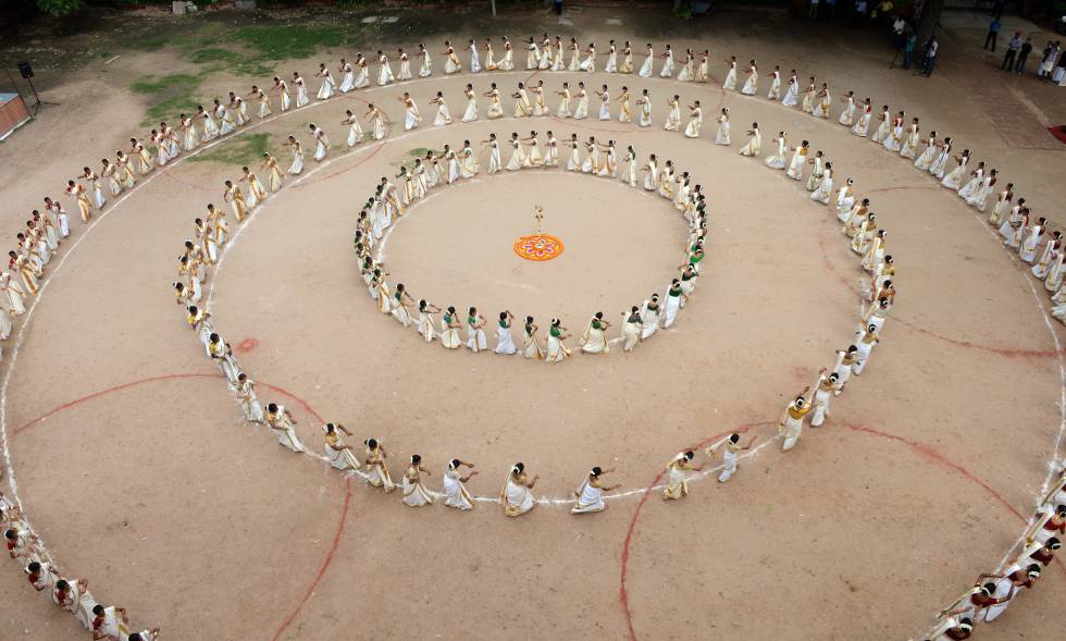 Jóvenes de Kerala pintan un mandala durante la danza Thiruvathirakali en el festival Onam.