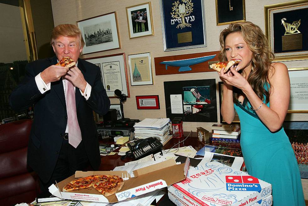 Donald Trump hincándole el diente a una pizza con Stephanie Myers, concursante de El aprendiz .