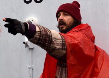 El actor Shia LaBeouf, con poncho naranja, junto a su instalación 'Él no nos dividirá'. El actor Shia LaBeouf, con poncho naranja, junto a su instalación 'Él no nos dividirá'.