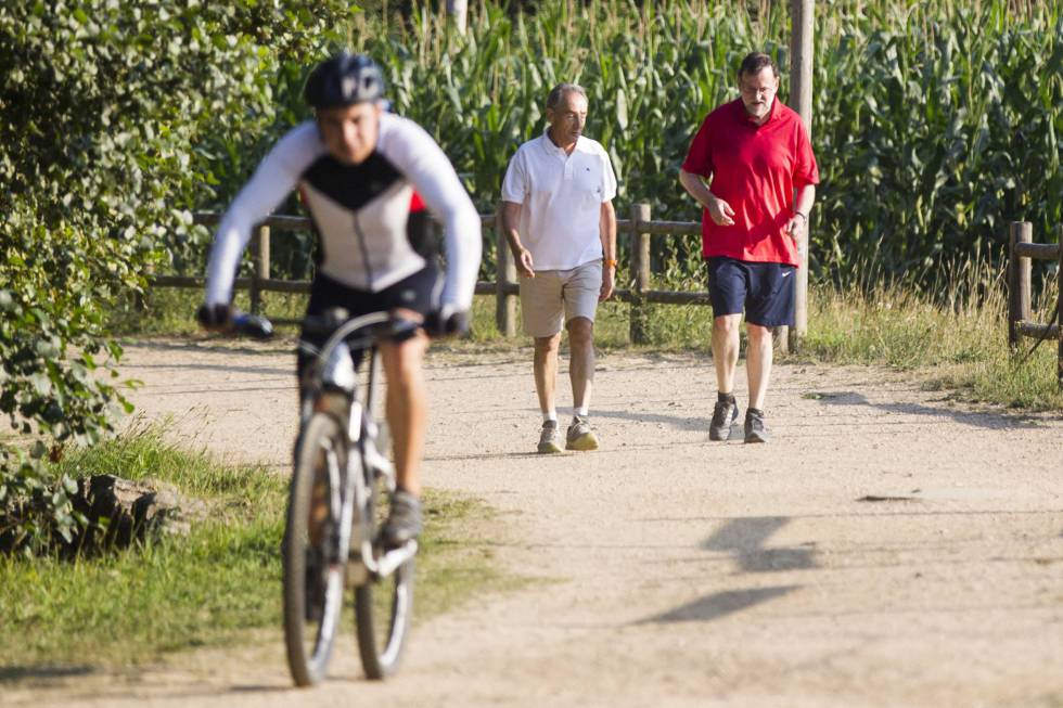 The Spanish PM (right) out jogging in 2014.