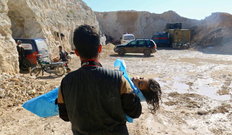 Un hombre con el cadáver de un niño tras el presunto ataque químico.