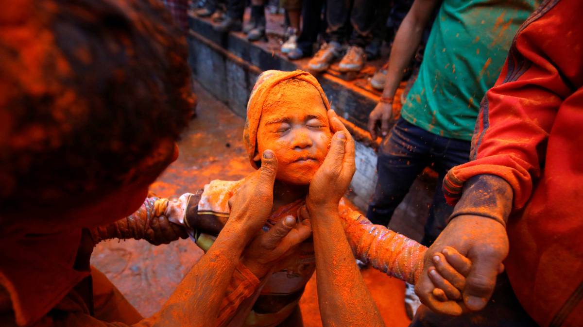 Un muchacho es embadurnado con polvo de bermellón durante el festival 'Sindoor Jatra' en Bhaktapur (Nepal).