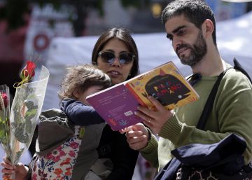 Una familia ojea un libro en un puesto del centro de Barcelona. 