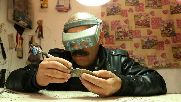 Un preparador de fósiles limpia un trilobites.