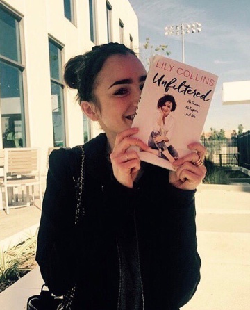 La actriz Lily Collins, con su libro, en una foto publicada en su Instagram.