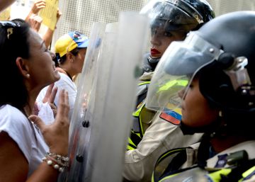 Riot police block the way to a march of Venezuelan opposition activists in Caracas on May 6, 2017. Thousands of women dressed in white marched in Venezuela's capital on Saturday to keep pressure on President Nicolas Maduro, whose authority is being increasingly challenged by protests and deadly unrest.  AFP PHOTO  FEDERICO PARRA