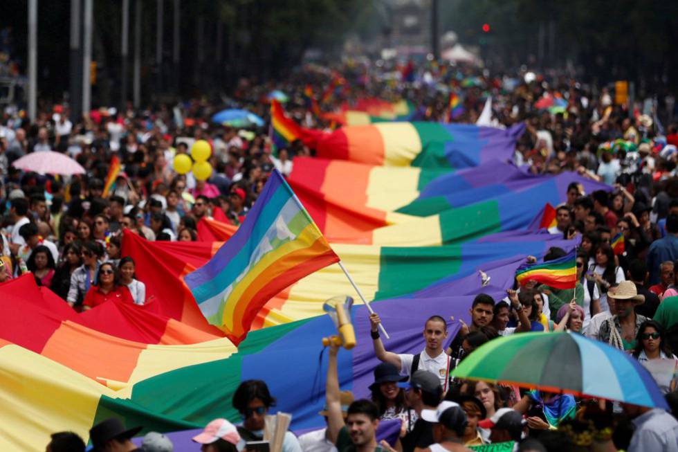 Los participantes del desfile anual del día del orgullo gay sostienen una gran bandera de arco iris en la ciudad de México.