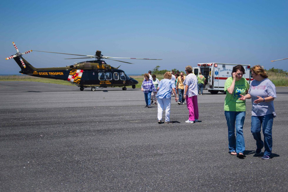 Sin hospital en la isla, las familias observan cómo una residente local es llevada en helicóptero debido a un dolor de pecho.