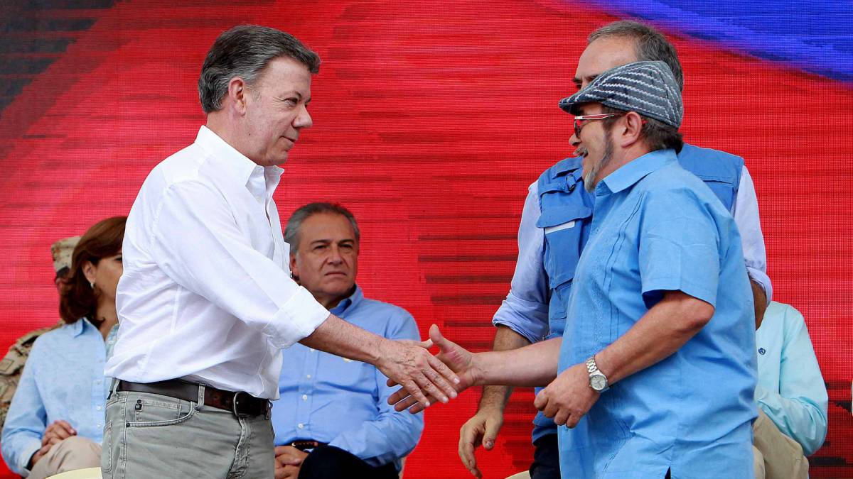 Juan Manuel Santos estrecha la mano del líder de las FARC, Timochenko.