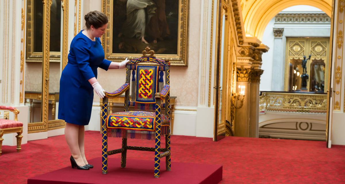 Una encargada de la exhibición de Royal Collection Trust acomoda el trono de Yoruba que fue obsequiado a Isabel II por Nigeria en 1956.rn