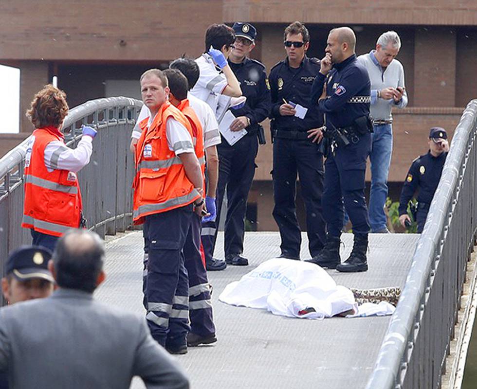 Police and medics stand near the body of Isabel Carrasco.