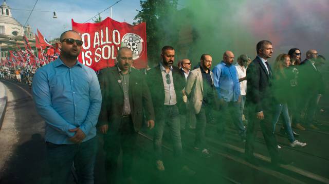 Simone Di Stefano, con traje y corbata, encabeza una manifestación de CasaPound.