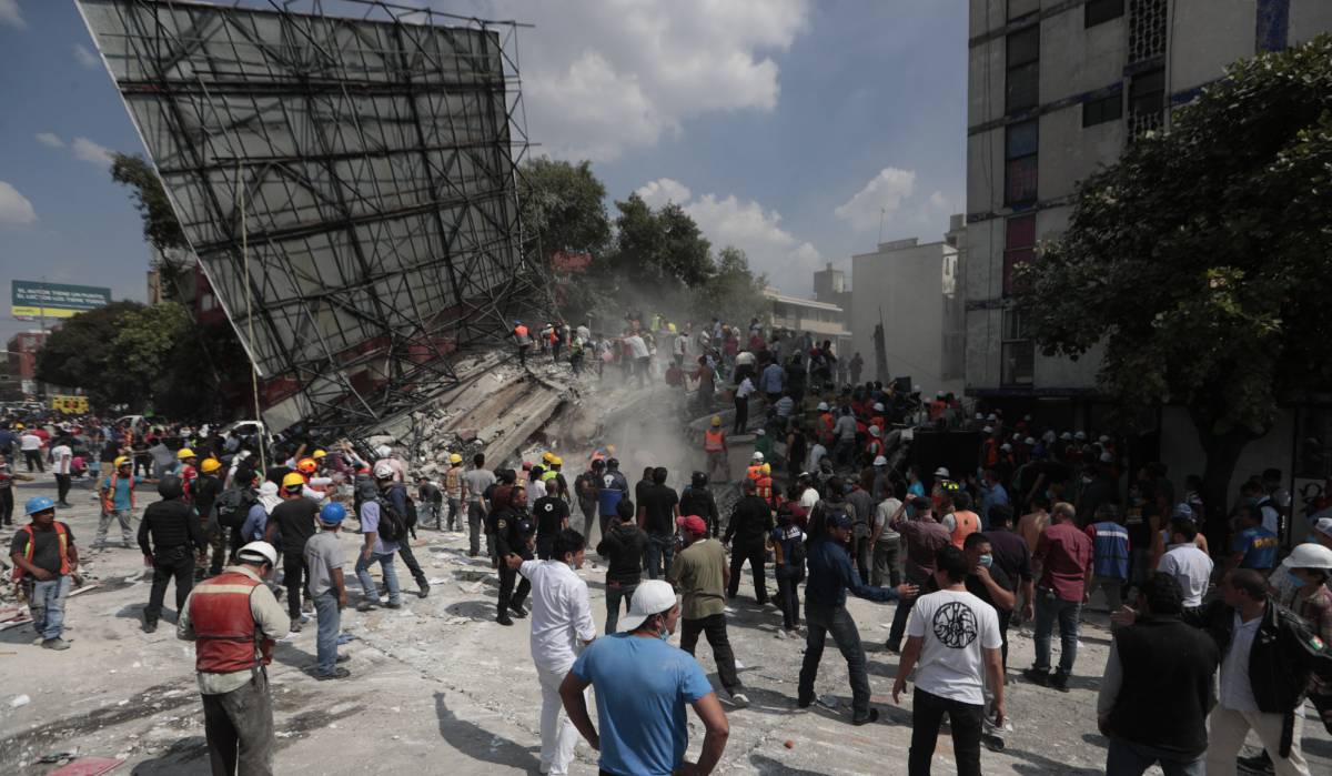 Equipos de rescate y voluntarios buscan supervivientes entre los escombros.