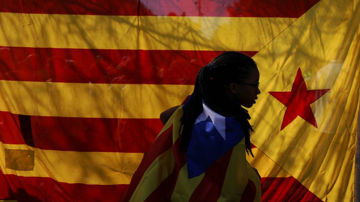 Una mujer junto a banderas esteladas.