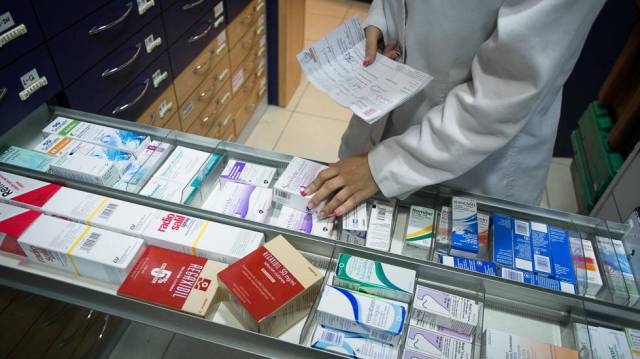 Una farmacéutica busca un medicamento en una farmacia de Barcelona.