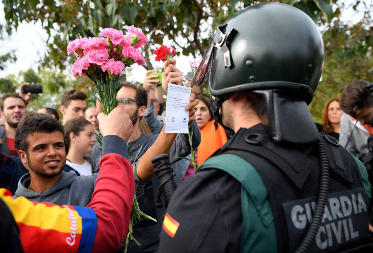 Manifestantes ofrecen claveles a un miembro de la Guardia Civil en Sant Juliá, el pasado 1 de octubre.