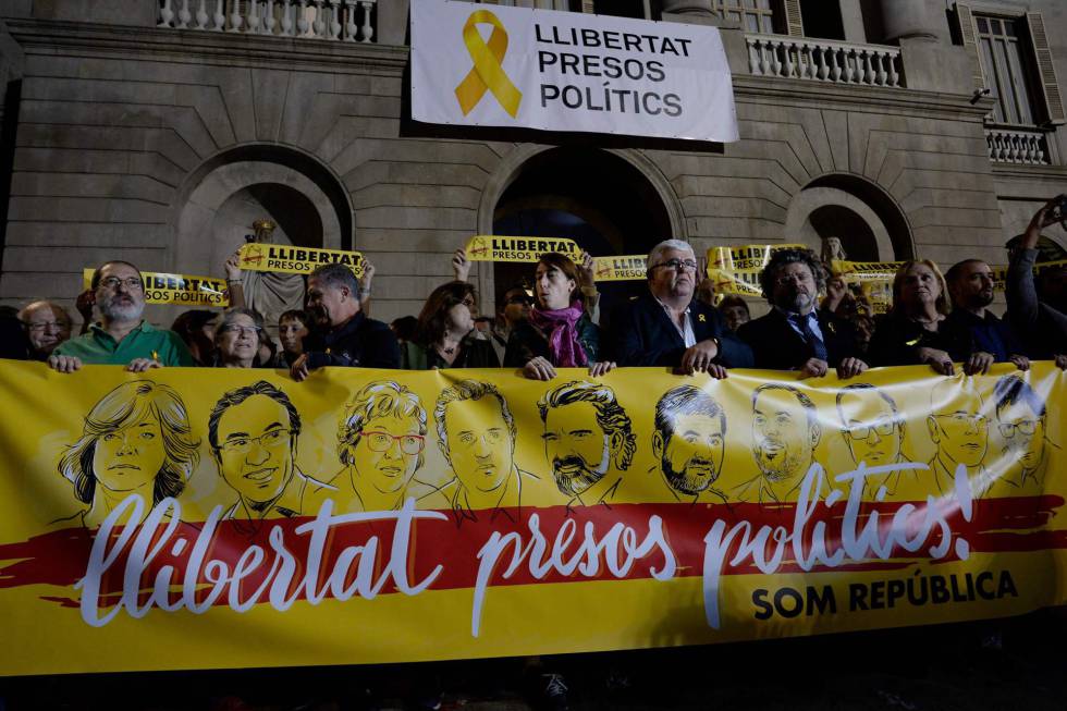 Protesters hold a banner reading “Freedom to political prisoners” with portraits of detained Catalan officials and the two ‘Jordis’.