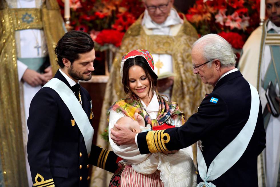 Carlos Felipe y Sofía de Suecia, con el príncipe Gabriel en brazos, y el rey Carlos Gustavo en la capilla del palacio de Drottningholm en Estocolmo.