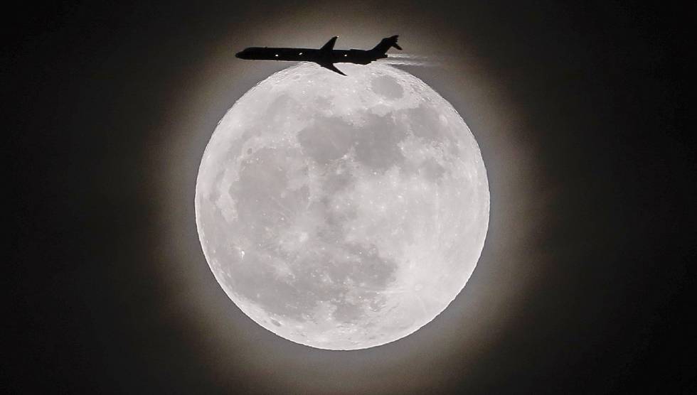 Un avión vuela junto a la Superluna en Avondale Estates, Georgia.
