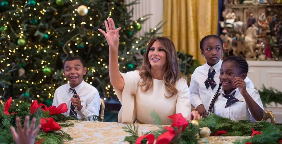 Melania Trump, la primera dama de los Estados Unidos, arroja un adorno navideño mientras hace guirnaldas con niños en la Casa Blanca.
