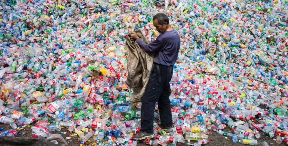 Trabalhador classifica garrafas de plástico para reciclar em Pequim.