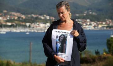 Diana Quer's mother with a poster of her missing daughter.