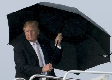 Donald Trump se cubre con un paraguas mientras se mojan su esposa y su hijo