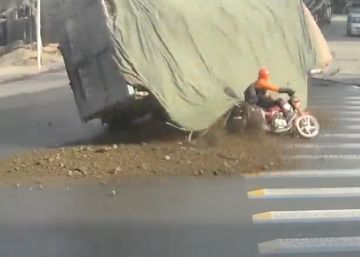 Un motorista se salva de ser aplastado por la carga de un camión
