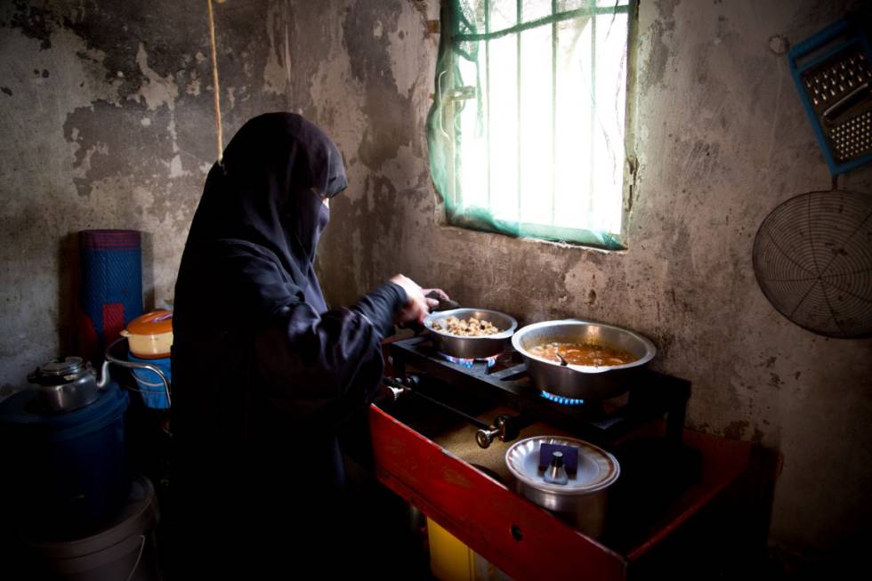 Una mujer prepara el almuerzo con la asistencia alimentaria de recibe del PMA. La familia, desplazada interna, ha podido comprar recientemente un hornillo de gas después de meses quemando cartones para cocinar.