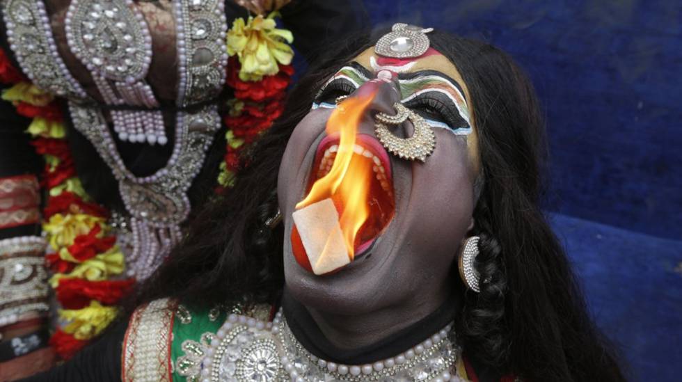 Un hombre indio vestido de la diosa hindú Kali realiza una actuación con fuego durante una procesión para conmemorar el festival Mahashivratri en Allahabad (India).