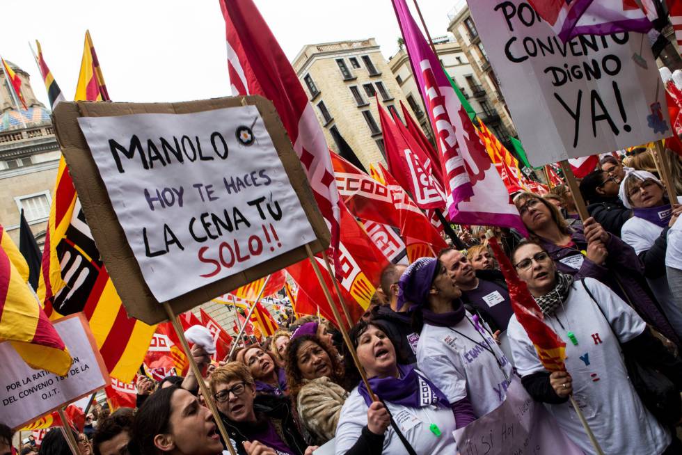 Women in Barcelona's Sant Jaume Square hold up a sign that reads