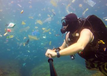 Un buceador se graba en Bali entre un océano de residuos plásticos