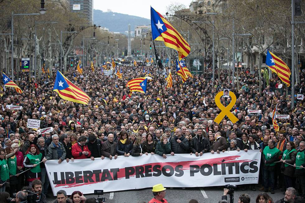 Protesters in Barcelona carry a sign demanding