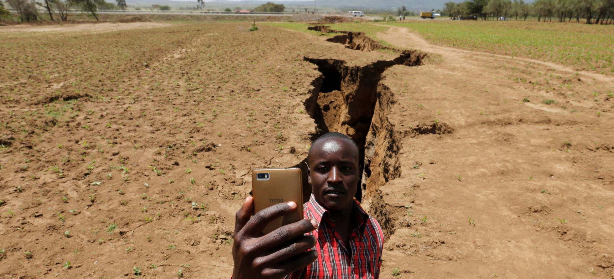 Un hombre se toma un selfi frente a la grieta que ha aparecido en Kenia.