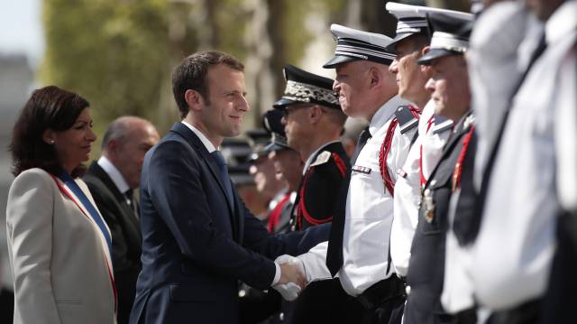 Macron y la alcaldesa de París saludan a policías.