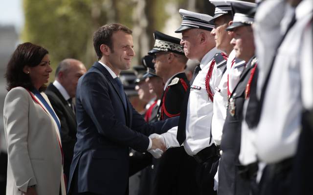 Macron y la alcaldesa de París saludan a policías.