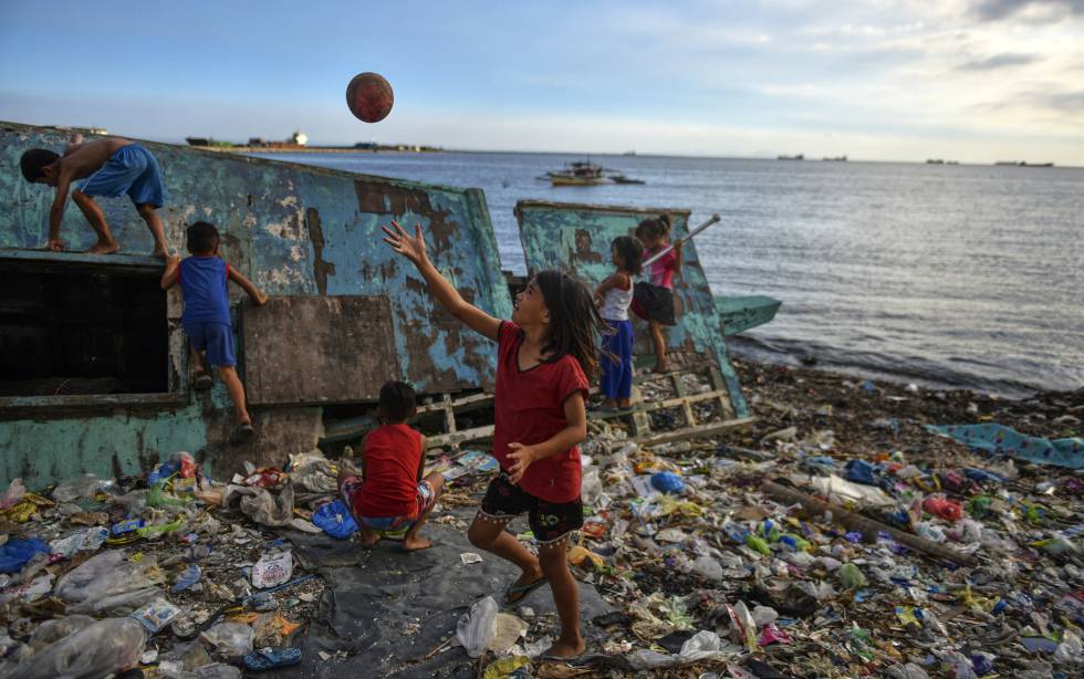 Niños juegan en una playa llena de plásticos en Manila (Filipinas).