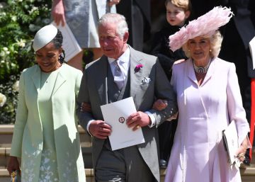 El príncipe Carlos de Inglaterra sale de la capilla de San Jorge del brazo de Doria Ragland, madre de su nuera Meghan, y de su esposa Camila de Cornualles.