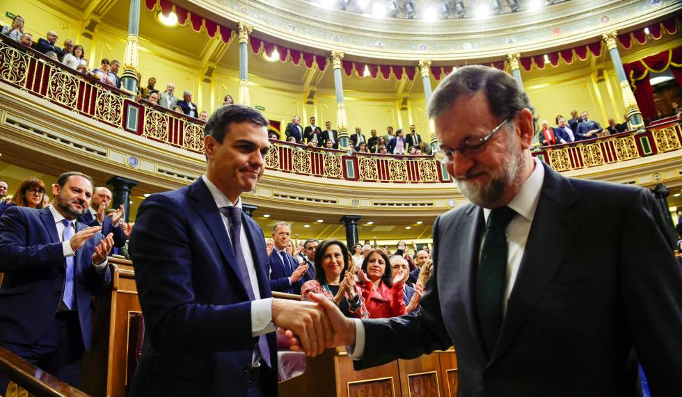 Spain's new Prime Minister Pedro Sanchez shakes hands with Mariano Rajoy.